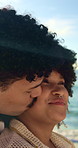 Kiss, hug and couple by beach on vacation, getaway or weekend trip for bonding in marriage together. Happy, outdoor and man embracing woman with love, trust and care by ocean on summer holiday.
