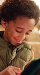 Smile, home and kid with tablet for online entertainment, game or scroll on educational app. African boy, sofa and happy with tech for digital puzzle, internet or browsing website for development