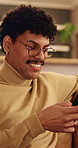Happy, man and scroll in home with phone, glasses or social media for reading digital news on weekend. Person, smile and browse in house with tech, mobile app or internet connection for text message.