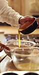 Baking, hands and mixing eggs in home for cake batter, pour raw ingredients and culinary skills. Baker, person and flour mixture in kitchen for handmade dessert, muffin snack and preparation process