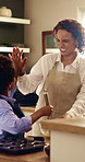 High five, mother and child baking in kitchen, smile and whisk eggs with good job for learning. African parent, boy and cooking at home, help and teaching kid with well done gesture for success