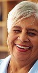 Face, laughing and senior woman in home with peace, smile and unwind with positive attitude on weekend. Portrait, happiness and person at apartment, retirement and funny with wellness on break
