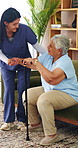 Woman, nurse and senior patient with cane in retirement home for assisted living or mobility. Caregiver, health worker or helping person with a disability or walking stick for elderly care in house