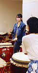 Playing, teacher and women with taiko drums for performance practice, demonstration or culture. Studio, asian female band or drummer instructor with sound for percussion, rehearsal class or tradition