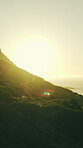 Drone, ocean and sunrise with mountain environment in summer for break, sightseeing or travel. Aerial, space and sunshine with view of sea outdoor in nature park for getaway, holiday or vacation