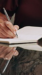 Woman, hands and writing with book in salon for hair booking, schedule or reminder on desk. Closeup, female person or hairdresser taking notes with diary or notebook for appointment in beauty parlor