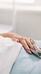 Hand, healthcare and rest with patient in hospital bed for healing, recovery or treatment. Finger, oxygen monitor and medical care with senior person in clinic for assistance, help or wellness