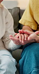 Home, sofa and parent with child for holding hands, comforting and support for relationship. Family, house and person with kid for bonding, connection and understanding for parenting, care and trust