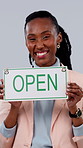 Face, black woman and open in studio with sign, advertising and welcome for small business launch. Portrait, female person and smile with poster for news, branding and hospitality on white background