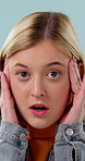 Explosion, surprise and face of woman in studio for good news, announcement and notification. Promotion, wow and shocked with person on blue background for results, alert and mind blown emoji
