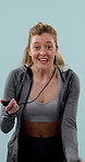 Face, motivation and stop watch with personal trainer woman in studio for development or training. Energy, excited and timing with happy coach on blue background for health or workout session