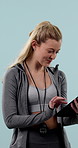 Fitness, results and tablet with personal trainer woman in studio for development or training. App, smile and stop watch with happy coach tracking progress of workout on blue background for planning