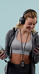 Dance, fitness and phone with personal trainer woman in studio for development or training. Funny, headphones and stop watch with happy coach on blue background for break or digital music streaming