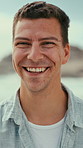Face, man and smile at beach for travel, adventure and calm morning on summer holiday. Portrait, male person and laughing at sea for fresh air, positive attitude and tropical vacation for summertime