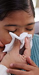 Sick child, tissue and care with parent in home for allergy, virus infection and flu season with daughter. Girl, person and blowing nose with help for cold, fever or disease with family support