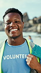 Laugh, face and volunteer on beach for cleaning, recycling and waste collection for earth day. Happy, portrait and man with trash bag for environment, reduce pollution and climate change for ngo