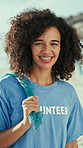 Face, volunteer and woman on beach for litter, recycling and waste collection for clean up. Happy, portrait and person with trash bag for environment, reduce pollution and climate change for ngo