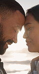 Travel, couple and happy with love at beach for anniversary getaway, sunshine and forehead touch. Flare, people and connection at ocean for romantic holiday, healthy relationship and marriage bonding
