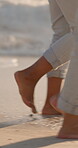 Love, walking and feet of couple at beach for romantic getaway, vacation and connection. Anniversary holiday, tropical adventure and travel with legs of man and woman outdoor for date and trust