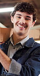 Carpenter, wood and face of man in warehouse for woodworking, factory manager and pride. Timber craftsman, smile and furniture production with person in workshop for manufacturing, lumber and laugh