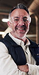 Carpenter, arms crossed and glasses with face of man for woodworking, factory manager and pride. Timber craftsman, laugh and furniture production with mature person in workshop for manufacturing