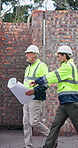 Architect, teamwork and people with document on construction site, talking and property development. Civil engineering, collaboration and discussion with floor plan, walking and building inspection