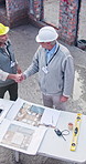 Architect, blueprint and handshake with team above for construction, development or greeting at site. Mature, paperwork and men shaking hands for design collaboration, welcome and talking outdoor