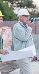Civil engineering, team and man with radio on construction site, communication or inspection update. Architect, discussion and mature people with blueprint, project management and walking with tech