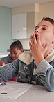 Sleeping, bored and tired with boy in classroom for learning issue, education and knowledge. Yawning, fatigue and course with male student at desk in school for exhausted, dreaming and lesson