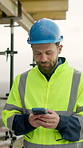 Architect, typing and man with phone on building site, online and communication with contact on web. Civil engineer, walking and person with mobile, texting and reading message on social media app