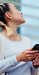 Woman, travel and phone in city with smile, sightseeing or explore outdoor with technology for online map. Female traveler, walking and mobile app for location, happy or tour downtown in Japan