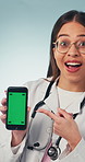 Happy, phone and face of doctor with green screen for medical news, telehealth app and advertising. Pointing, portrait and woman with tech, mockup space and healthcare info on studio background