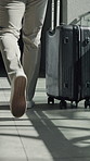 Person, walking and travel with suitcase in office building for job opportunity or schedule. Employee, traveler or legs with luggage for flight booking, work trip or business commute in workplace