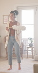Headphones, dancing and woman in home for spring cleaning, chores or dusting on weekend. Happy, duster and person with audio tech for listening to music, playlist or album online for housekeeping.