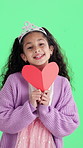 Face, heart and child with tiara on green screen for valentines day, love and emoji in studio. Happy, portrait and girl with smile, crown and card for care, magic and fantasy on chromakey background