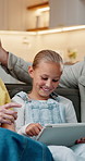 Happy, parents and daughter at house with tablet, social media and browsing website for movies. Smile, people and child in living room with digital, streaming film and comedy video for weekend break