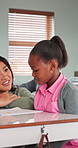 Assessment, help and teacher with girl in classroom for assistance, learning and explain lesson. Teaching, woman and child with assignment answer for education, understanding or development at school