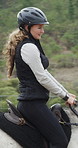 Equestrian, woman and horse riding on ranch with helmet, sports exercise or training for competition. Female person, jockey and outdoor in countryside with animal, hobby and companion for adventure.