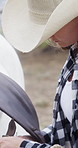 Work, cowgirl and prepare horse on ranch for rider safety, fasten stirrup or horseback ride routine. Equestrian, woman and getting ready with animal for equine hobby, protection gear or adjust saddle