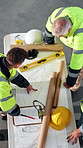 Above, people and conversation with blueprint for architecture, explain design or project management. Team, talk and review floor plan at construction site with collaboration, renovation or building.