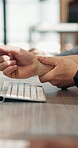Hands, wrist pain and person at desk with massage, rheumatoid arthritis or carpal tunnel syndrome. Fatigue, joint strain from typing and muscle tension with employee in office, relief or pressure