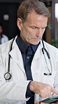 Doctor, tablet and mature man in hospital for medical information, records and telehealth app. Serious person, technology and scroll on internet for healthcare schedule, results and research