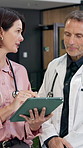 Doctors, tablet and team in hospital for discussion, medical information and telehealth app for advice. Mature woman, man and technology to talk of internet for healthcare, results and research