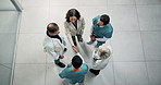 Handshake, above and team of doctors in hospital with medical deal, agreement or partnership. Collaboration, people and healthcare employees shaking hands with director for support in clinic.