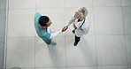 Handshake, above and doctor with nurse in hospital with medical deal, agreement or partnership. Collaboration, people and healthcare employees shaking hands for support, service or contract in clinic