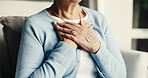 Elderly, woman and hands in retirement home with chest pain, heartburn symptoms and health problem. Uncomfortable, senior person and acid reflux in living room with indigestion, illness and disease.