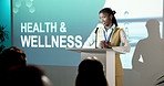 Expert, woman and presentation in seminar with audience, health and wellness trade show for advice. Person, speaking and screen in convention with healthcare proposal, medical innovation or research.