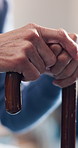 Hands, cane and senior woman in retirement home for balance, mobility support or medical aid. Walking stick, comfort and person with a disability for pension, assisted living or healthcare in house