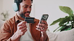 Phone, credit card and man in home for payment, online shopping and internet banking with app. Mobile, debit and happy person on sofa with digital sign up for financial budget, savings and investment