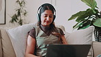 Smile, typing and laptop with woman on sofa for social media, reading blog and streaming service. Headphones, email and podcast with person in living room of home for website, sign up and relax